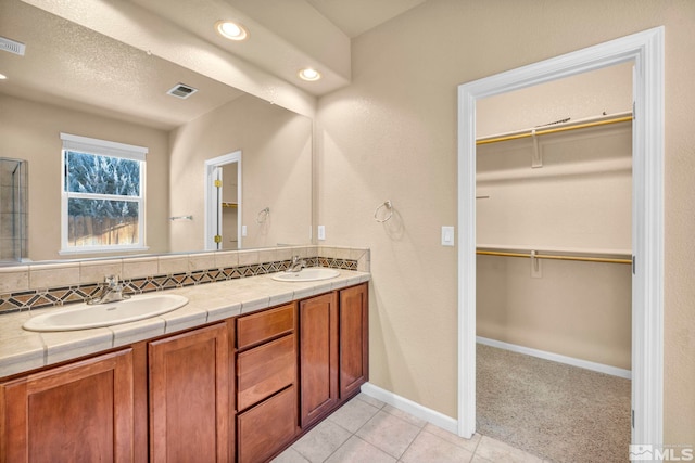 bathroom featuring vanity, a textured ceiling, backsplash, and tile patterned floors