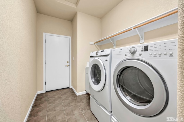 clothes washing area with separate washer and dryer and light tile patterned floors