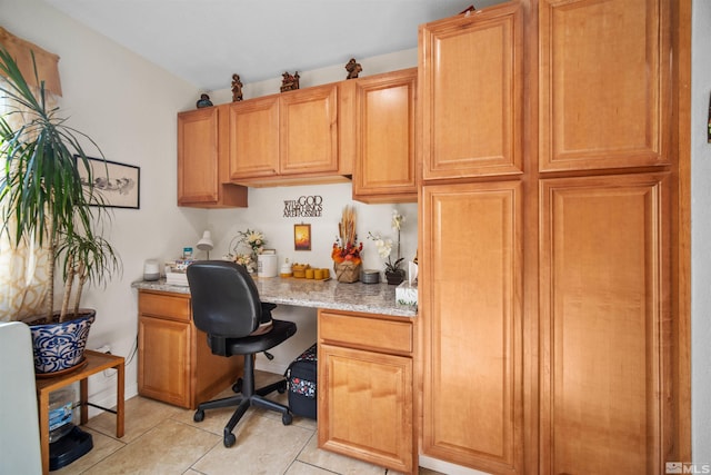 home office featuring light tile patterned flooring and built in desk