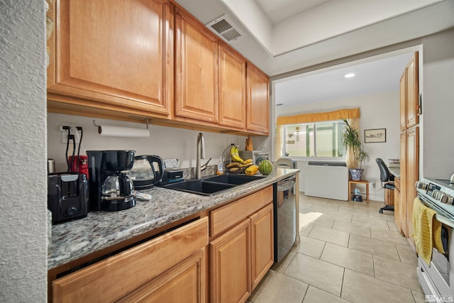 kitchen featuring sink, black dishwasher, light stone counters, stainless steel range oven, and light tile patterned flooring