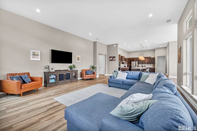 living room with recessed lighting, light wood-style floors, and visible vents