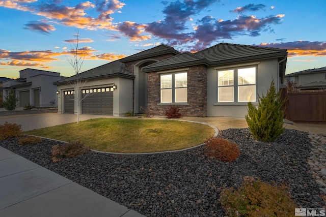 view of front facade with concrete driveway, a tile roof, stucco siding, a garage, and stone siding