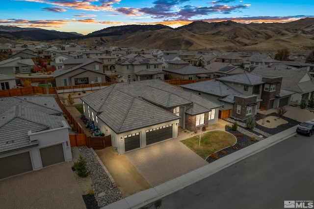 aerial view at dusk featuring a residential view and a mountain view