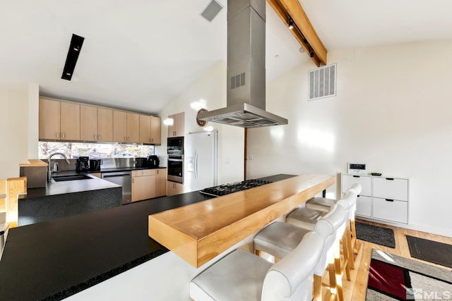 kitchen with beam ceiling, sink, light brown cabinets, stainless steel appliances, and island exhaust hood