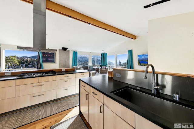 kitchen with light brown cabinetry, sink, light hardwood / wood-style flooring, and stainless steel gas cooktop