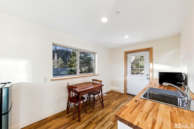 kitchen with hardwood / wood-style floors, butcher block counters, and sink