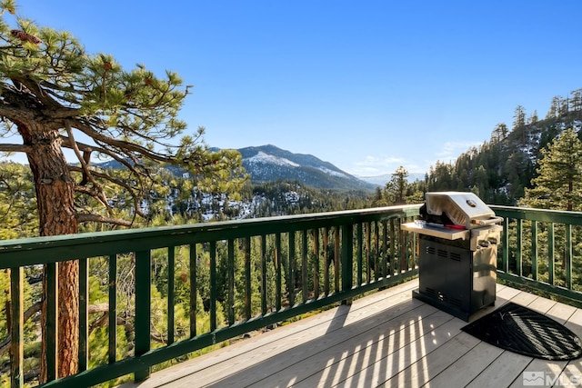 wooden deck with a mountain view and a grill