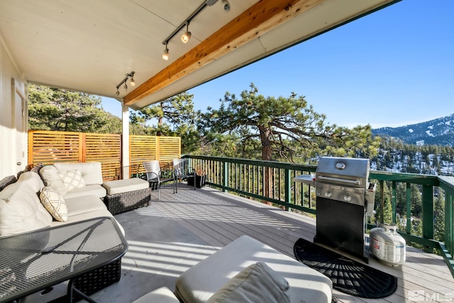 deck featuring an outdoor living space, a grill, and a mountain view