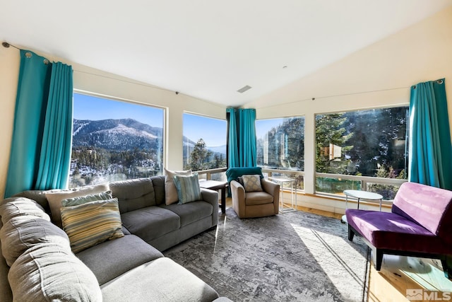 sunroom / solarium featuring a mountain view, a healthy amount of sunlight, and lofted ceiling