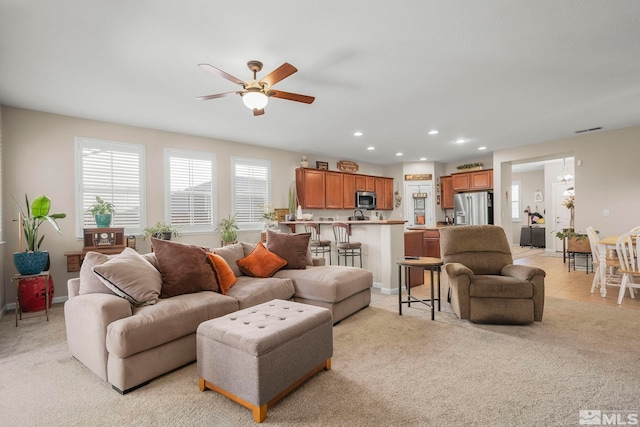 living room with ceiling fan and light colored carpet