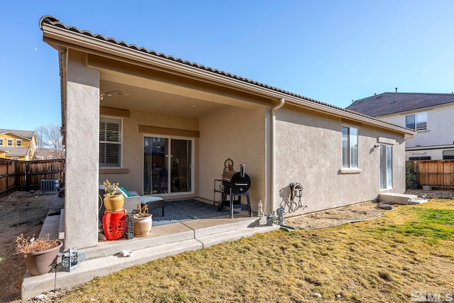 back of house featuring central AC unit, a patio area, and a lawn