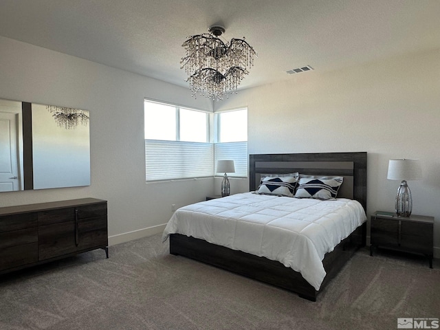 bedroom with carpet flooring, a textured ceiling, and an inviting chandelier