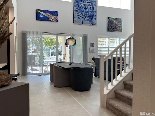 living room featuring french doors, tile patterned flooring, and a high ceiling