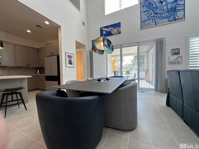 interior space with light tile patterned flooring and a towering ceiling