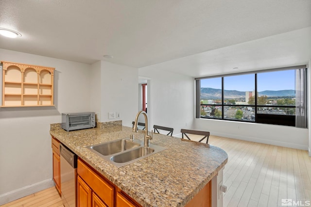 kitchen with kitchen peninsula, a mountain view, sink, and stainless steel dishwasher