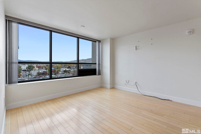 empty room with a mountain view and light hardwood / wood-style floors