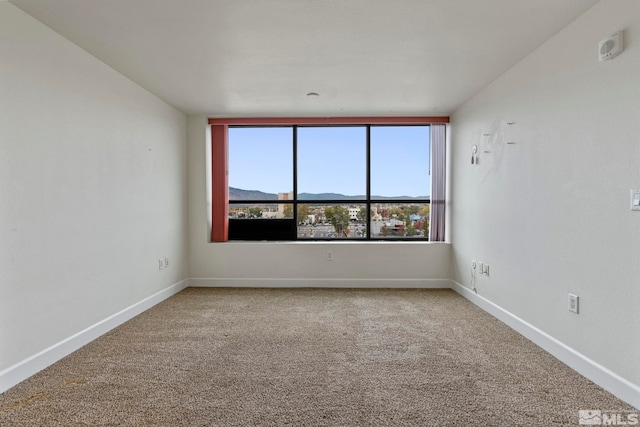 spare room featuring carpet flooring and a mountain view