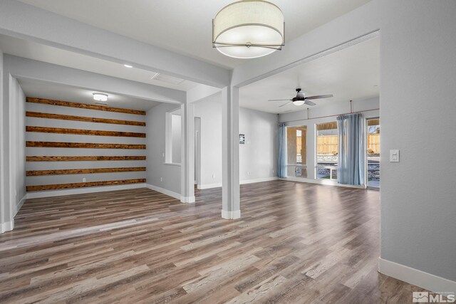 unfurnished living room featuring ceiling fan and wood-type flooring