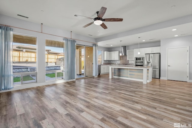 unfurnished living room featuring light wood-type flooring and ceiling fan