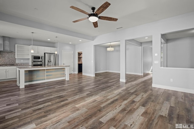 unfurnished living room with ceiling fan and dark wood-type flooring