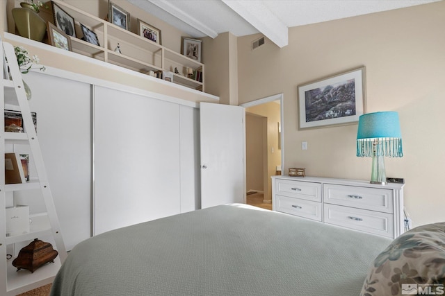 bedroom with beam ceiling and a closet