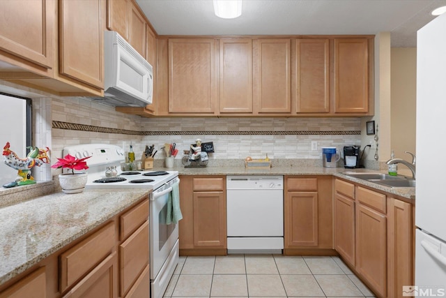 kitchen featuring backsplash, light stone counters, white appliances, sink, and light tile patterned floors