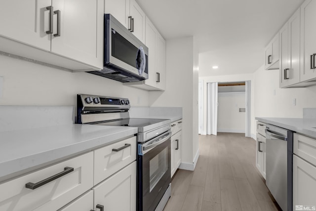 kitchen featuring light wood-type flooring, white cabinetry, and appliances with stainless steel finishes