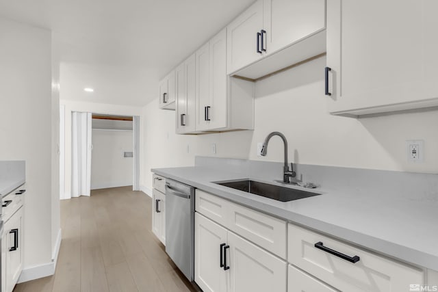 kitchen featuring dishwasher, light hardwood / wood-style floors, white cabinetry, and sink