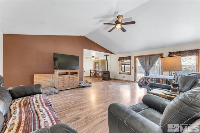 living room featuring ceiling fan, light hardwood / wood-style floors, and lofted ceiling