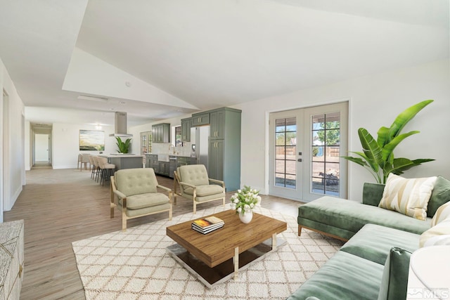 living room featuring french doors, vaulted ceiling, and light hardwood / wood-style flooring