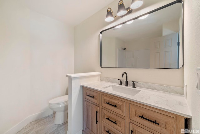 bathroom with a shower, vanity, and toilet