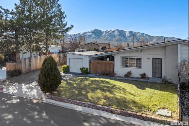 ranch-style house with a mountain view, a garage, and a front lawn