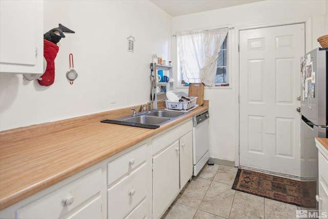 kitchen featuring white cabinets, stainless steel fridge, white dishwasher, and sink