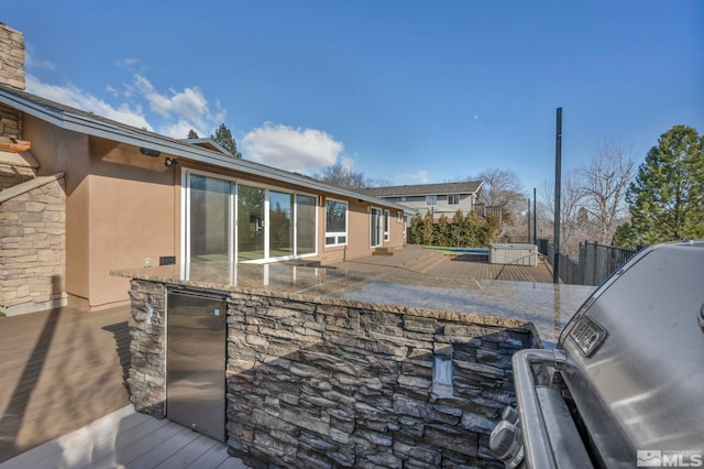 view of patio / terrace with a grill, a swimming pool, and exterior kitchen