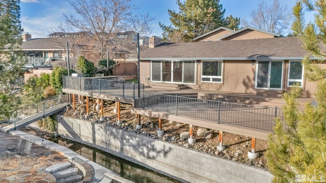 rear view of house featuring a wooden deck