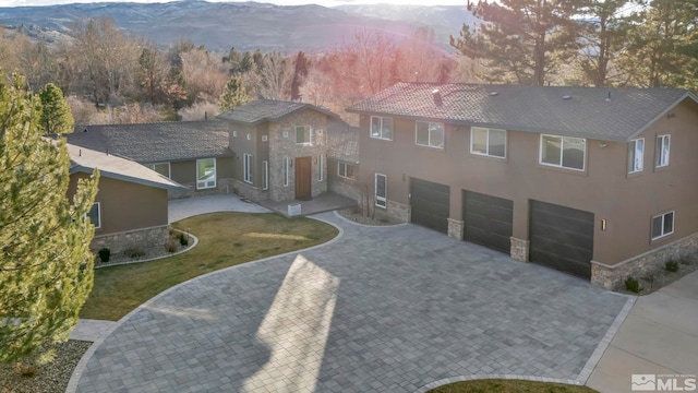 view of front of property featuring a mountain view, a front yard, and a garage