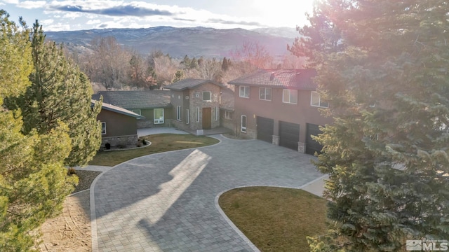 view of front of home featuring a mountain view, a front lawn, and a garage