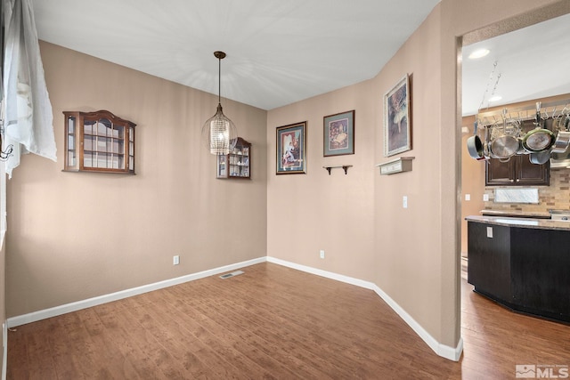 unfurnished dining area featuring wood-type flooring