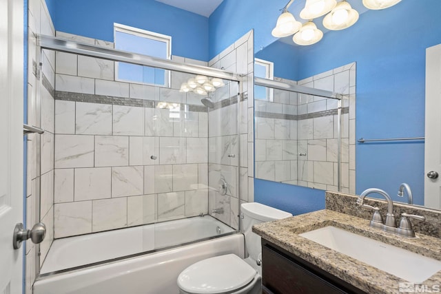 full bathroom featuring combined bath / shower with glass door, toilet, and vanity