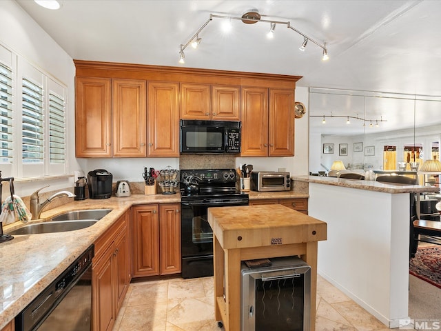 kitchen with a breakfast bar, sink, black appliances, a center island, and butcher block countertops