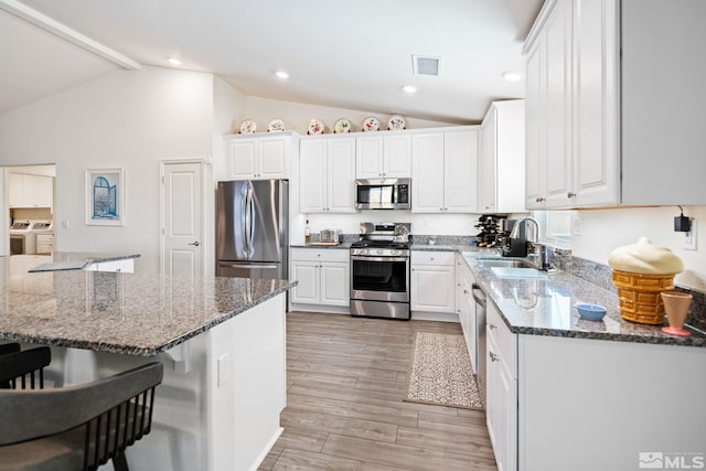 kitchen with washing machine and clothes dryer, white cabinets, and appliances with stainless steel finishes