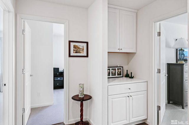 hall featuring light colored carpet