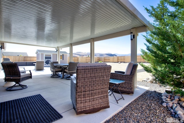 view of patio with a mountain view and a shed