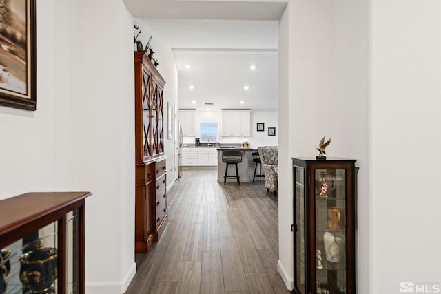 hall featuring beverage cooler and hardwood / wood-style flooring