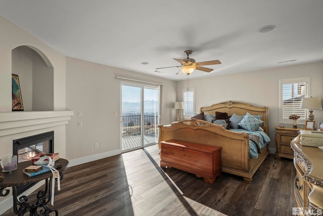 bedroom with ceiling fan, dark wood-type flooring, access to outside, and multiple windows