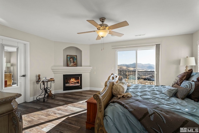 bedroom featuring a mountain view, ceiling fan, dark hardwood / wood-style flooring, and access to outside