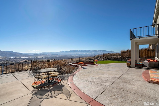 view of patio with a mountain view, a balcony, and an outdoor living space