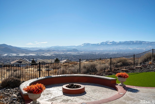 view of patio with a mountain view and an outdoor fire pit