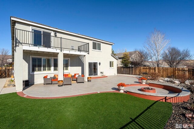 back of house with a yard, an outdoor living space, a balcony, and a patio area