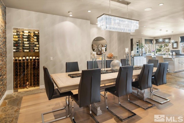 dining area with light hardwood / wood-style flooring and a notable chandelier